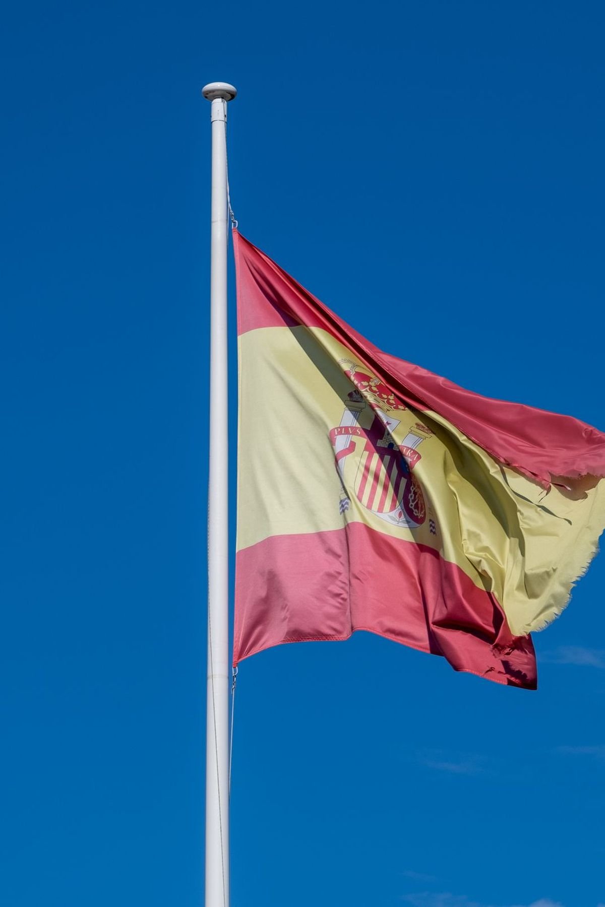 Bandera de España ondeando: nacionalidad española por residencia